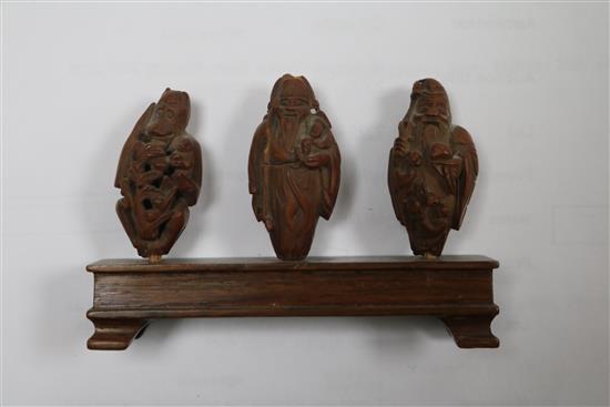 A set of six Chinese peach stones carved as immortals and a monkey, rosewood stands, each approx. height 4cm